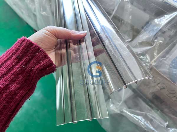 Hand zeigt Rückseite des bronzefarbenen Polycarbonat Basis-Kappe-Verbinderprofils – durchgängig UV-stabilisiertes Material