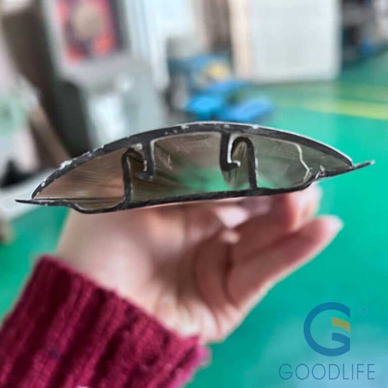 Hand hält bronzefarbenen Polycarbonat H-Lock-Verbinder – detaillierter Querschnitt des zweiteiligen Basis-Kappe-Rastsystems