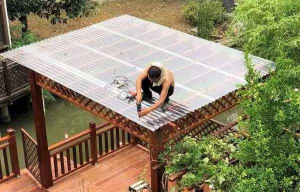Fachinstallateur montiert Polycarbonat-Welldachplatte auf chinesischem Pavillon mit wetterfesten EPDM-Befestigern